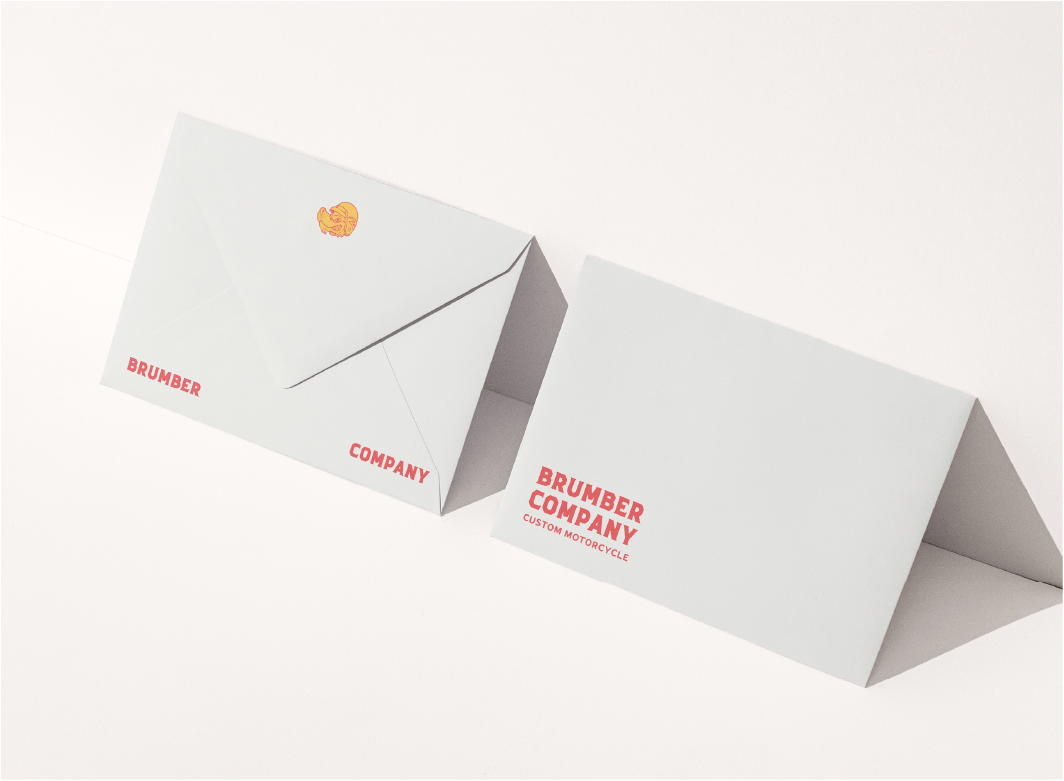 The front and back of a custom printed envelope, leaning against a wall.